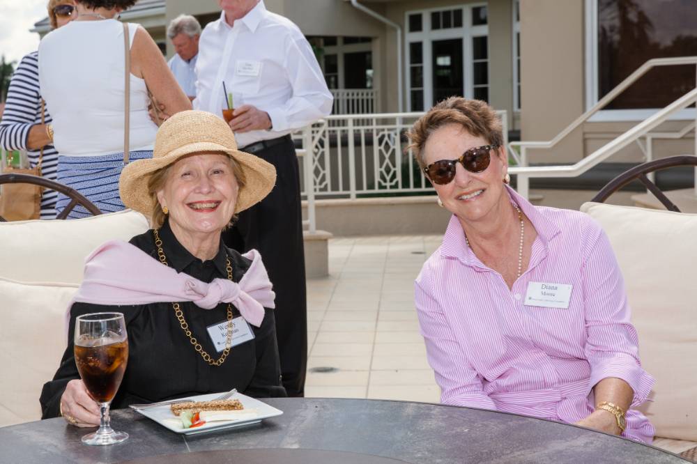 Woman in a sunhat smiling with another guest at Naples 2019